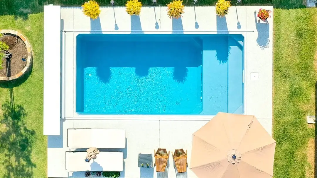 Top view of outdoor Plungie pool with loungers and umbrella.