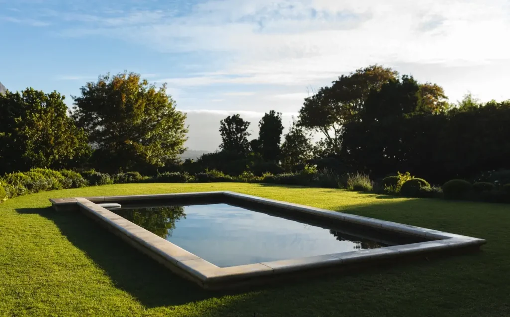 A sleek rectangular fiberglass pool installed in a beautifully landscaped garden, designed by top fiberglass pool manufacturers.