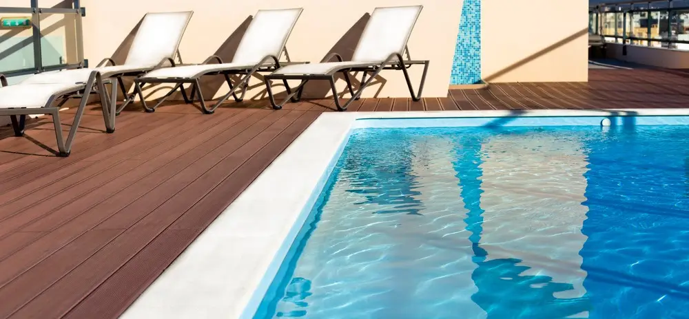 A rooftop swimming pool with EPS-insulated decking and reclining chairs for relaxation.