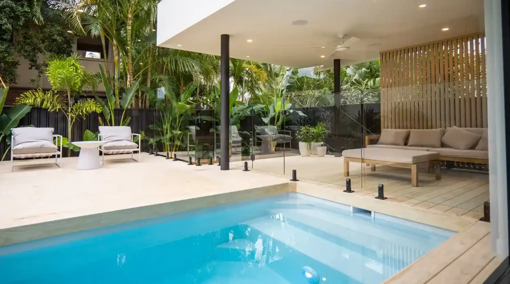 Modern backyard with Plungie Original pool, deck, lounge, and tropical plants.