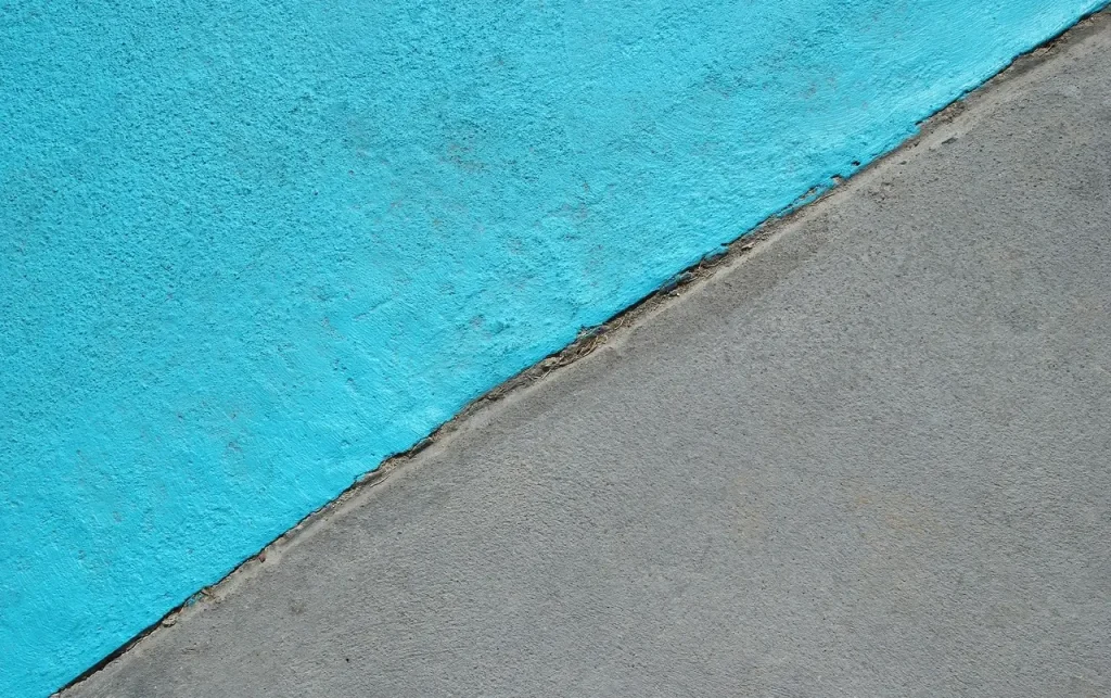 A close-up view of a textured blue and gray concrete surface painted with concrete pool paint for pool finishing.