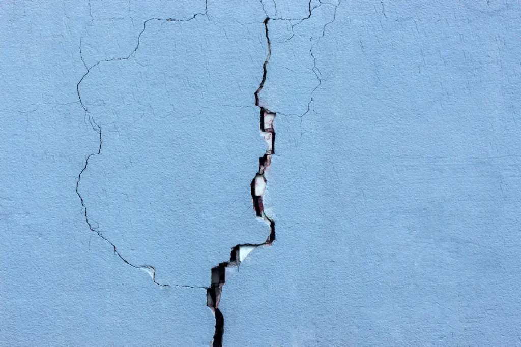 A cracked and damaged pool deck surface showing visible fractures in the concrete.