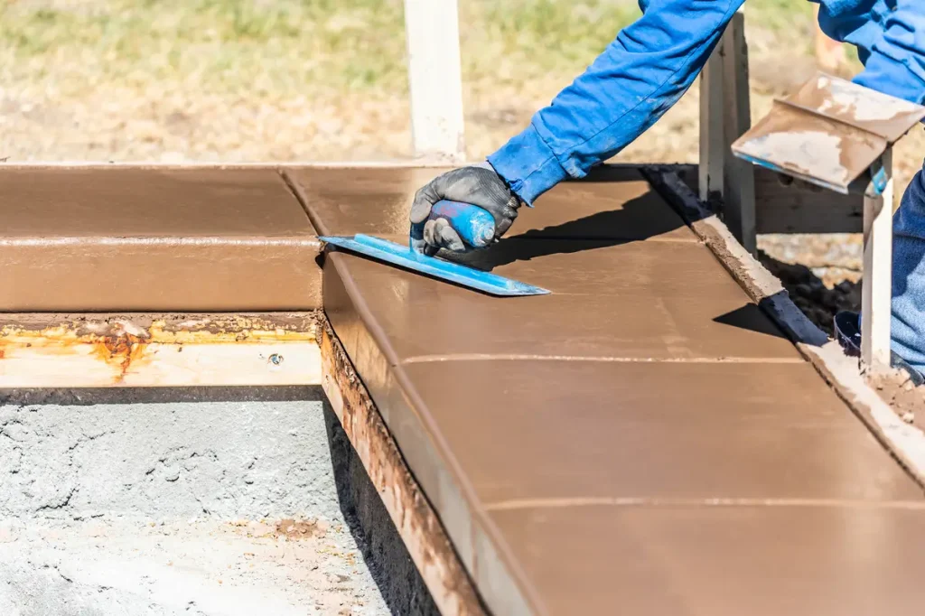 Worker applying finishing touches during a Concrete Pool Deck Repair.