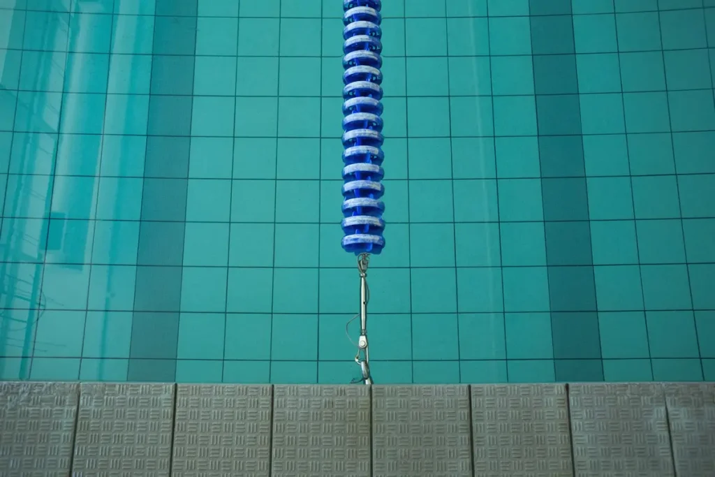 Technician installing a concrete anchor in a swimming pool.