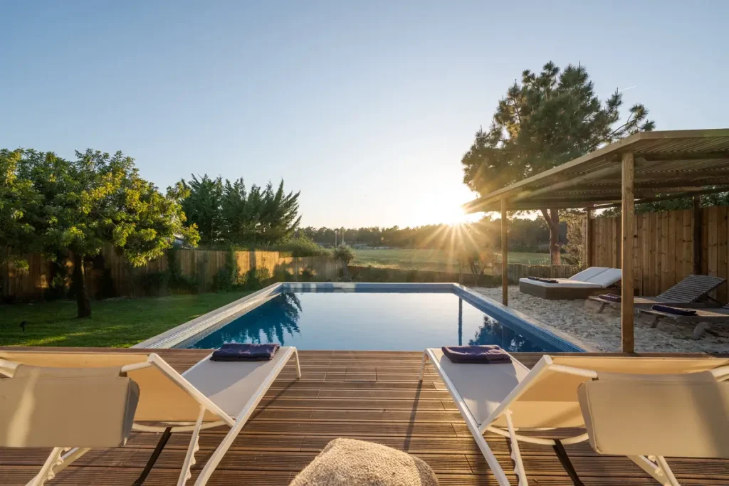 A serene pool with a wooden deck at sunset, demonstrating the value of affordable above-ground pool prices.