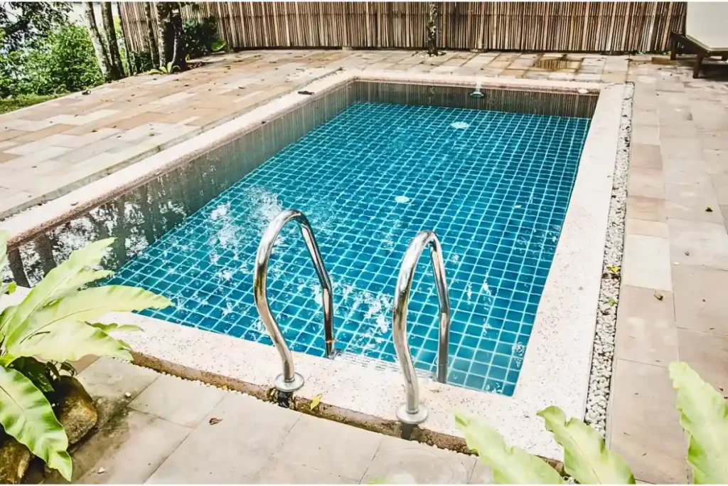 A compact DIY fiberglass pool with a tiled interior and a minimalist patio design.