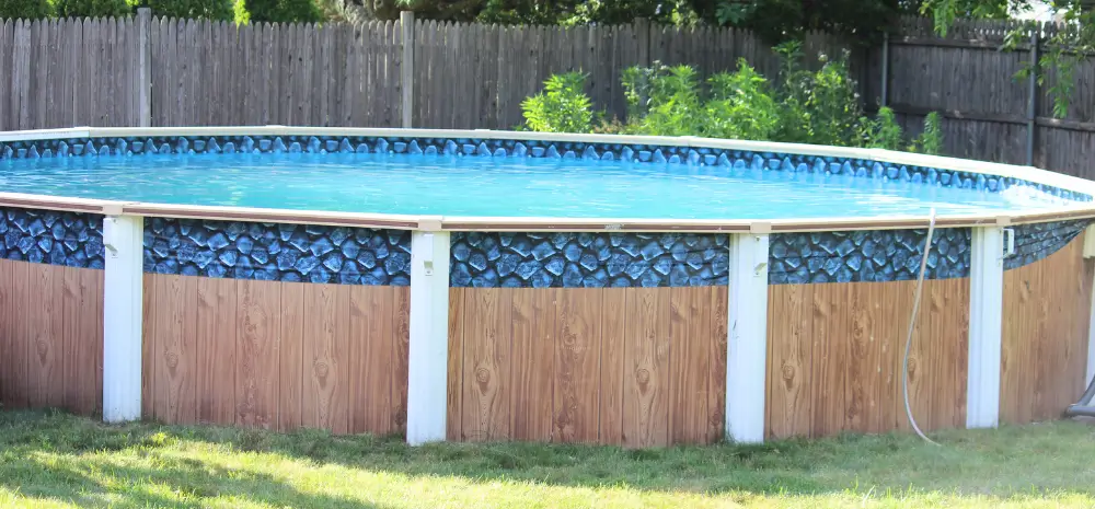 A fully installed above ground pool base with a solid structure and decorative exterior finish.