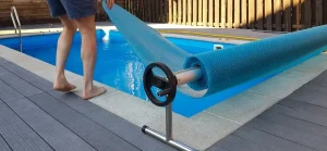 A man installing an above ground pool covers to protect the pool from dirt and weather elements.