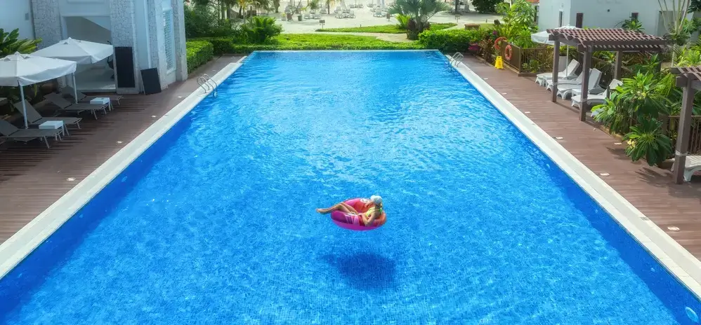 A luxurious tropical fiberglass pool in sunny Florida, surrounded by tropical plants