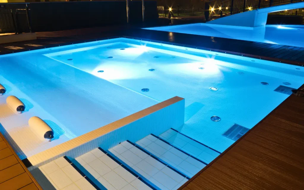 A luxurious swimming pool in Florida illuminated with LED lights, creating a stunning night-time ambiance.